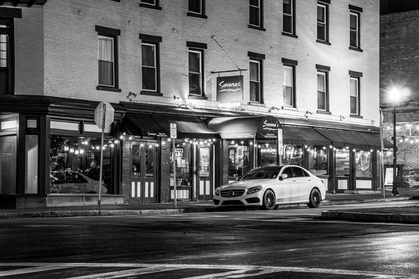 A black and white photo of a car parked in front of an Italian restaurant in the Rondout Historic District.